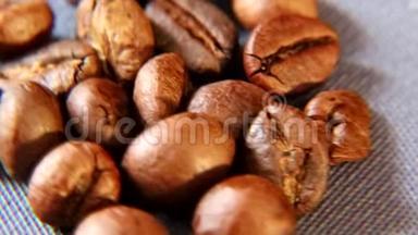 棕色的芳香咖啡颗粒在桌子上粗布的基材上旋转。
